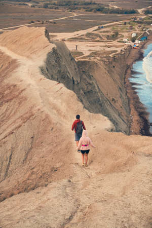 Couple walks the promontory of the sea, enjoying the view and fresh air.