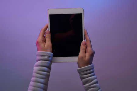 Close-up of hands with tablet and blank black screen.の写真素材