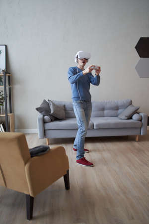 Man with virtual reality headset is playing game.