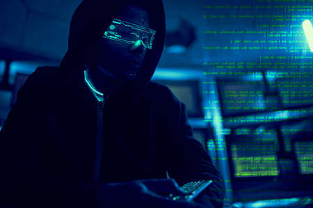 Cyber hacker breaks into databases to obtain information using a computer.