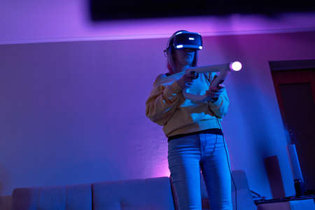Woman with virtual reality headset are playing game and fighting.