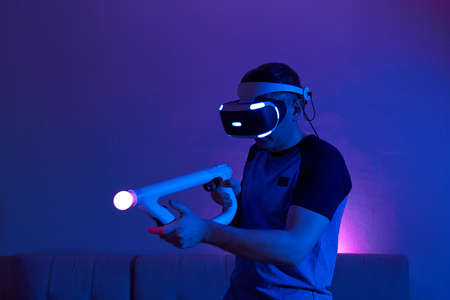 Man with virtual reality headset and joystic is playing game