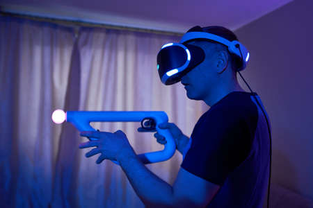 Man with virtual reality headset and joystic is playing game