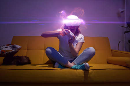 Woman with virtual reality headset and joystic is playing game.の写真素材
