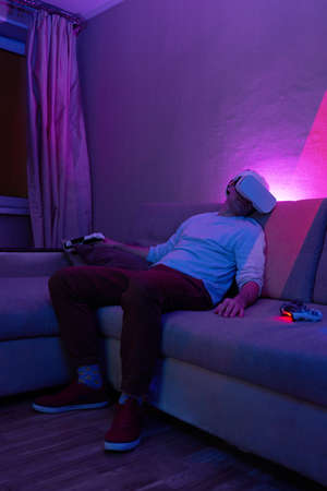 Man played a lot of games and got tired, fell asleep sitting on a sofa in a vr headset and with a...
