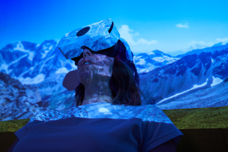 Woman uses virtual reality glasses to go to another point of light and see mountains.の写真素材