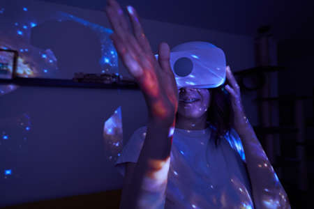 Woman is using virtual reality headset. Elements of this image furnished by NASA.