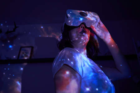 Woman is using virtual reality headset. Elements of this image furnished by NASA.