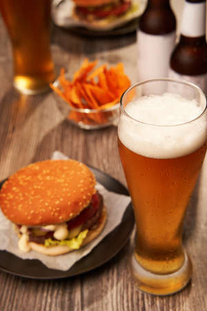 Bottles and glasses of beer with hamburgersの写真素材