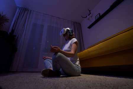 Woman uses virtual reality glasses to relax and meditate.の写真素材