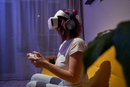 Woman with virtual reality headset and joystic is playing game.の写真素材