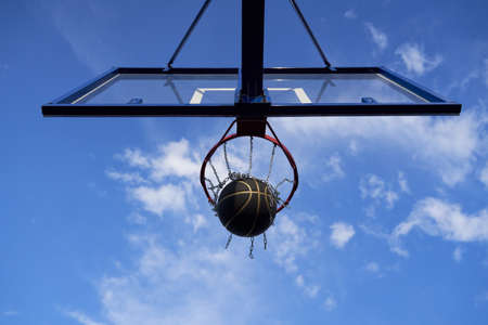 Street basketball ball falling into the hoop.