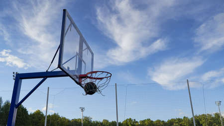 Street basketball ball falling into the hoop.