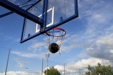 Street basketball ball falling into the hoop.