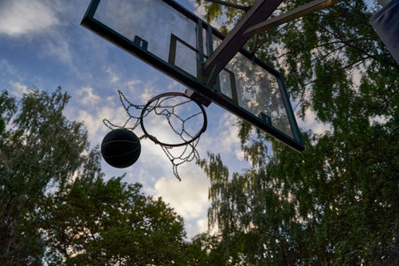 Street basketball ball falling into the hoop.