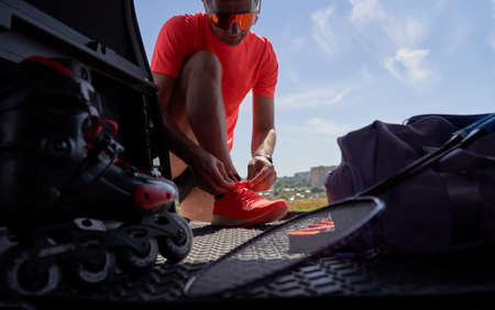 Sportsman tying laces for training in trunk outdoors.の写真素材
