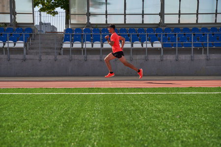 Sport man athlete is running on treadmillat the stadiumの写真素材