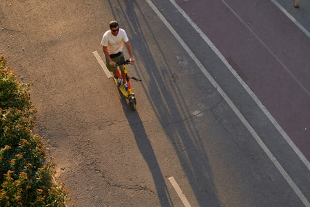 Man is riding on kick scooter on cycling road. Top aerial view.の写真素材