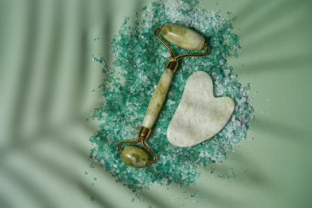 Green jade face roller and Gua Sha scraping for beauty facial massage therapy.の写真素材