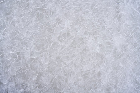Fresh ice surface texture. Winter background with frozen snowflakes and snow mounds.