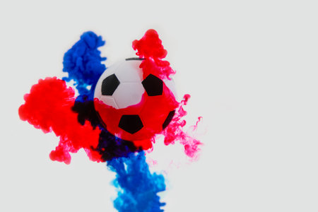 Soccer ball with red and blue color splash on white background.の写真素材