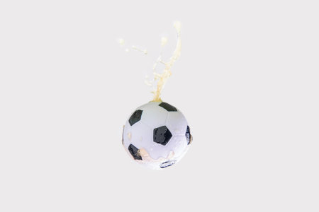 Soccer ball in beer splash on white background.の写真素材