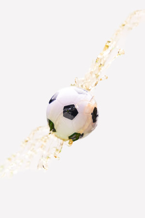 Soccer ball in beer splash on white background.の写真素材