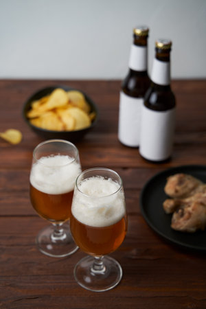 Two glasses with beer, snacks and bottlesの写真素材