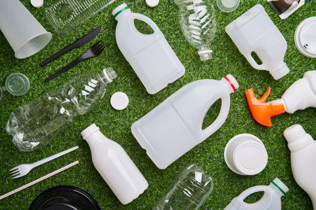 Plastic collected for recycling on green grass background.