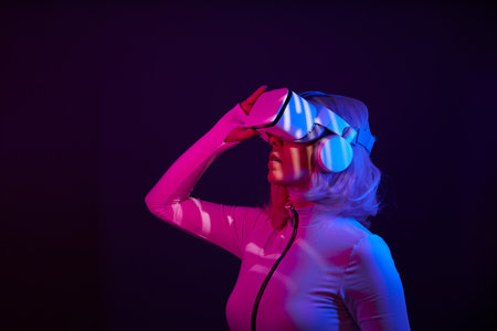 Woman in virtual reality goggle in neon colors.の写真素材