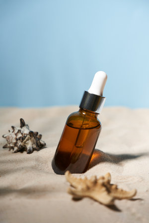 Summer sunscreen essence on sand background with seashells and starfish.の写真素材