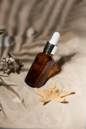 Summer sunscreen essence on sand background with seashells and starfish.の写真素材