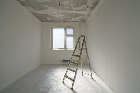 Interior of a new apartment without finishing in gray tones with folding metal ladder-step ladder.の写真素材