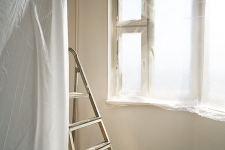 Folding metal ladder-stepladder against the background of painted walls in the roomの写真素材