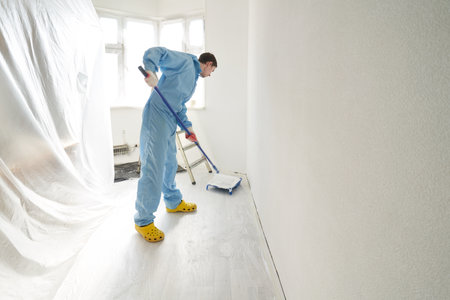 Man dipping a roller into a palette of paint.の写真素材
