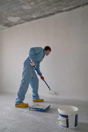 Man paints the ceiling with a rollerの写真素材