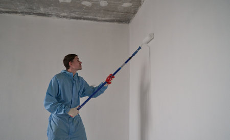 Man paints the ceiling with a rollerの写真素材