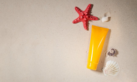 Summer sunscreen cream on sand background with starfish and shell.の写真素材