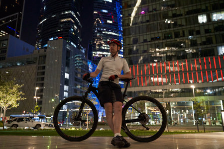 Man cyclist on the background of the night streets of the city.の写真素材