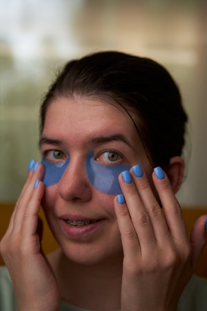 Woman is using cosmetic patches on face.の写真素材