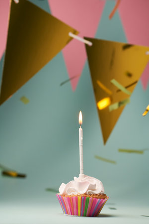 Colorful cupcake with single birthday candle.の写真素材