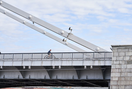 Man riding on bicycle across the bridge in the city.の写真素材