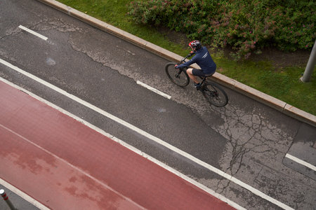 Man riding on bicycle on a bike path in the city. View from above.の写真素材