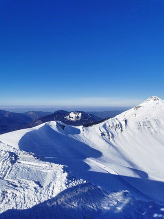 Pristine mountain snowscape under a clear blue sky.の写真素材