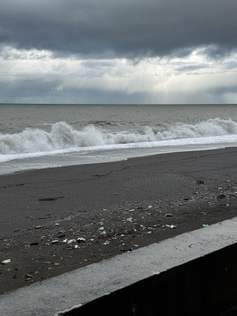 Stormy beach with dark clouds and polluted shoreの写真素材