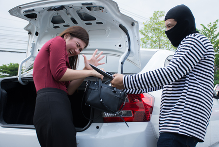 Male robber robbing a handbag threatening with knife to scared Asian woman,criminal concept