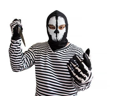 Outlaw bad man hold a knife pointing the target/Robber with knife and looking at camera isolated on a white background/Selective focus/criminal conceptの写真素材