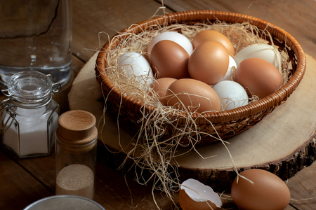 Close up of eggs in basket with flavoring on the wood table