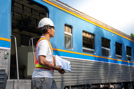 Picture of Asian engineer wearing safety helmet with checking train for maintenance in station/Engineer Conceptのeditorial素材