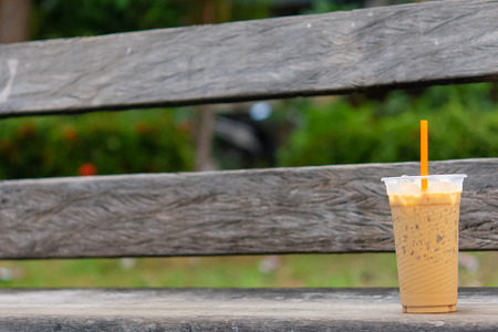 Coffee cool moment the sun is low. On a wooden chair in the parkの写真素材